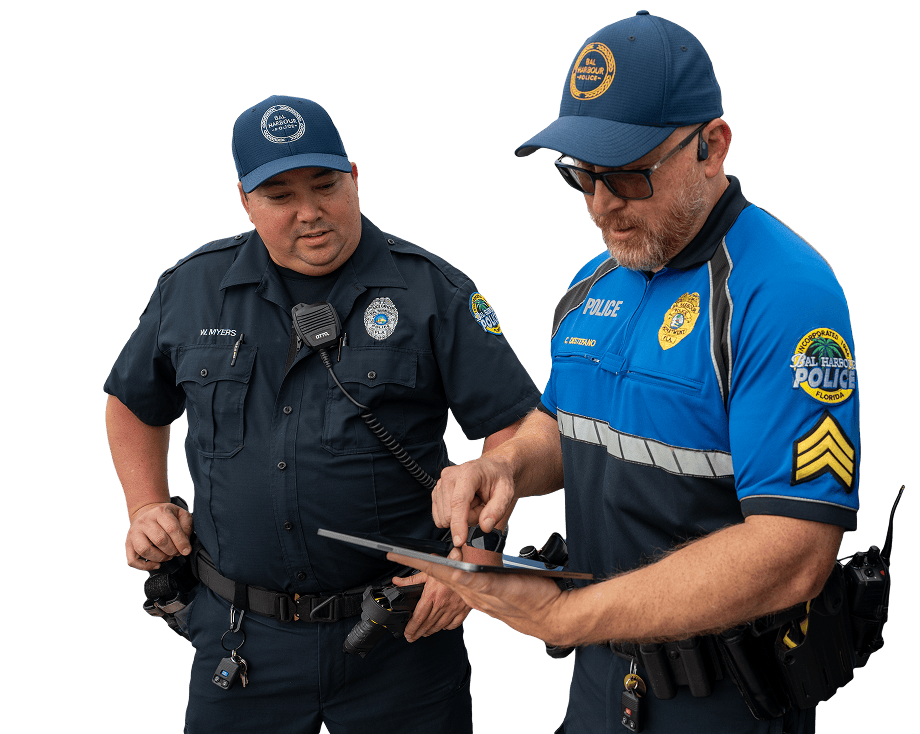 Two policeman standing and looking at a tablet.